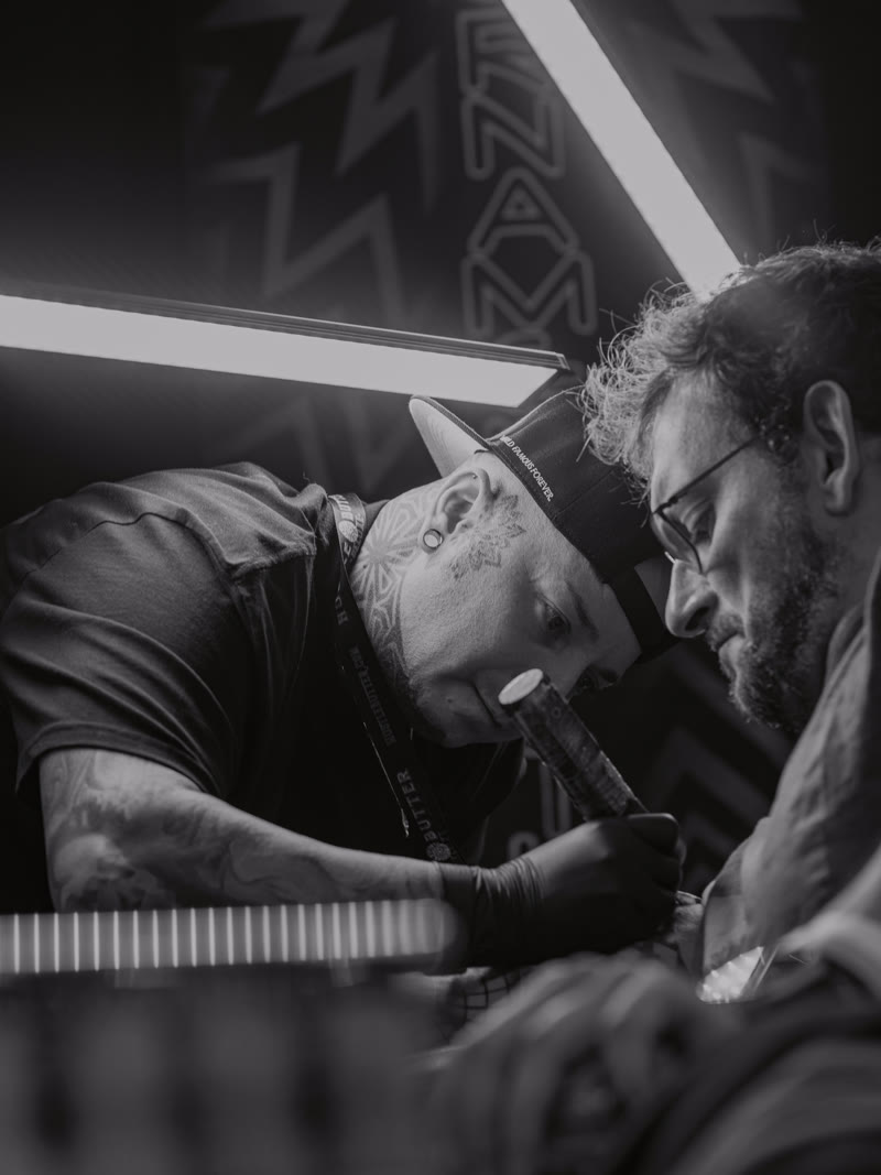Two artists leaning into a piece at the expo, black and white