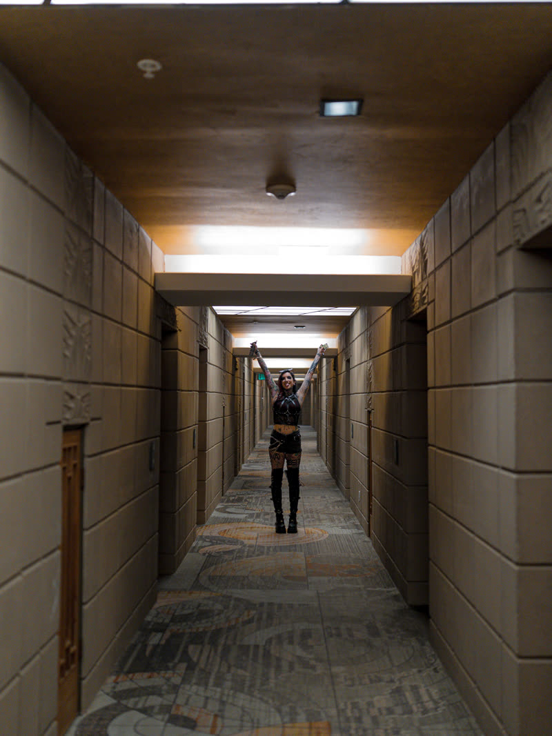 Arms raised at the far end of a hotel corridor