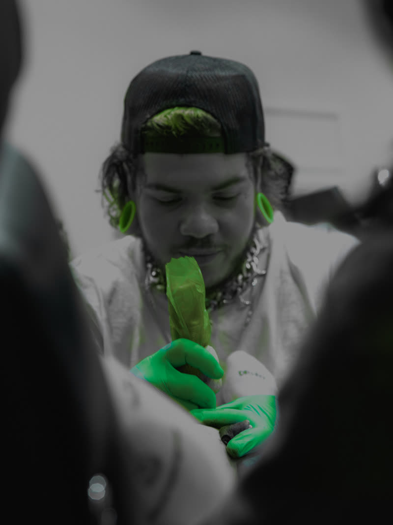 Artist at work, green nitrile glove the only colour in the frame