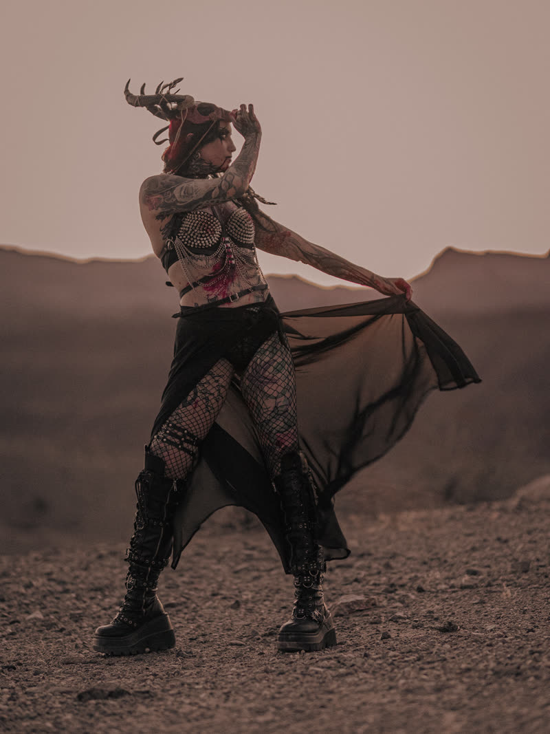 Black veil pulled wide against the desert