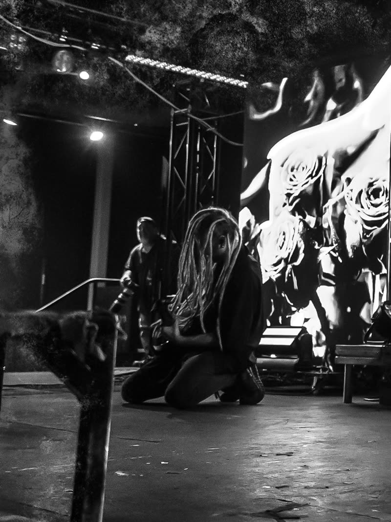 Crouched at the edge of the stage, black and white