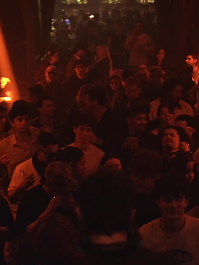 The floor at capacity, hands up through the haze