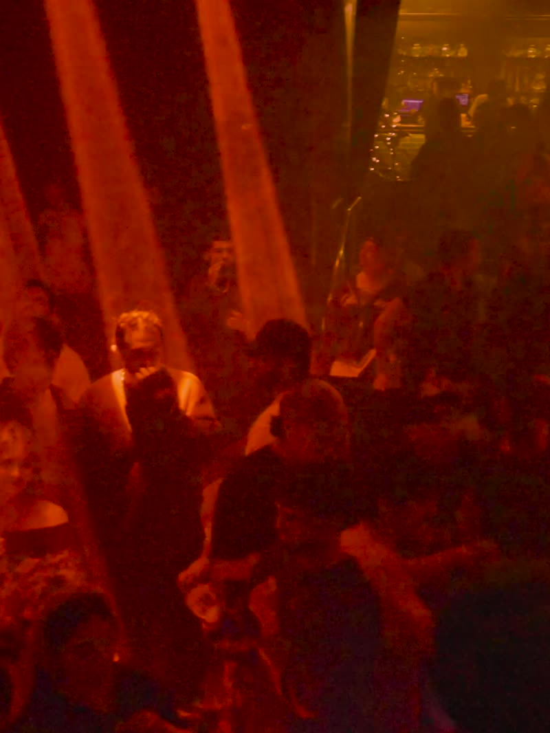 Red haze over the crowd, beams cutting through
