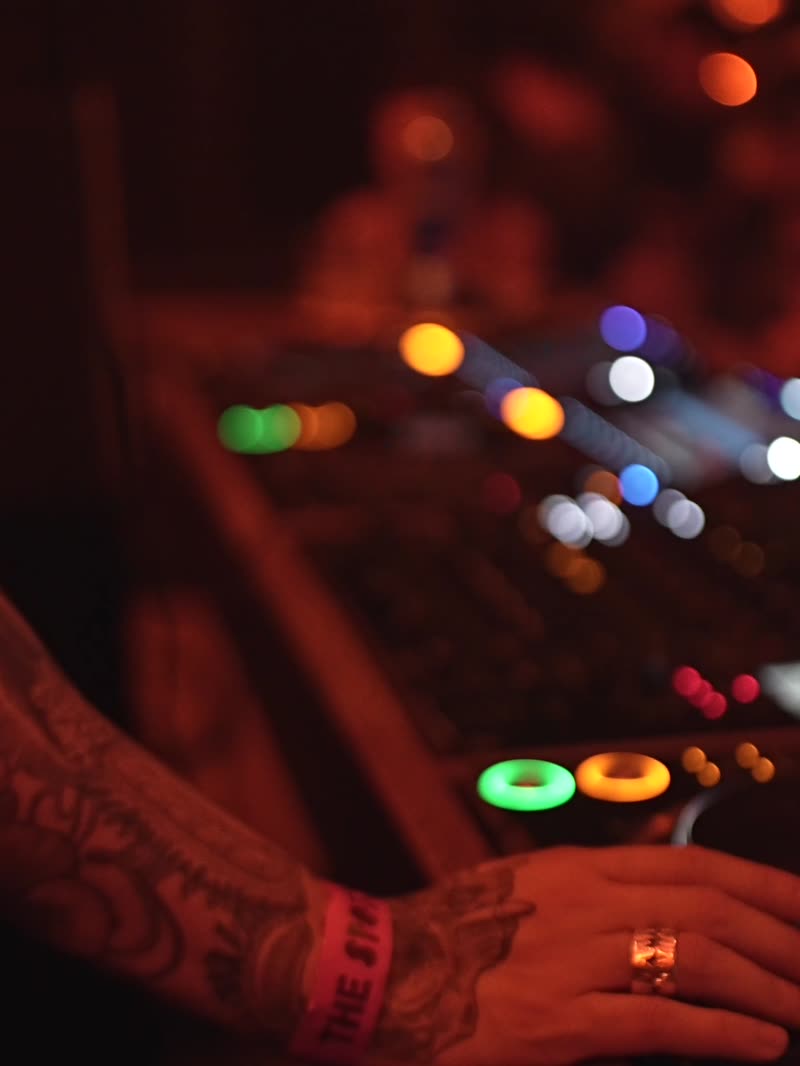 Tattooed hands working the CDJs