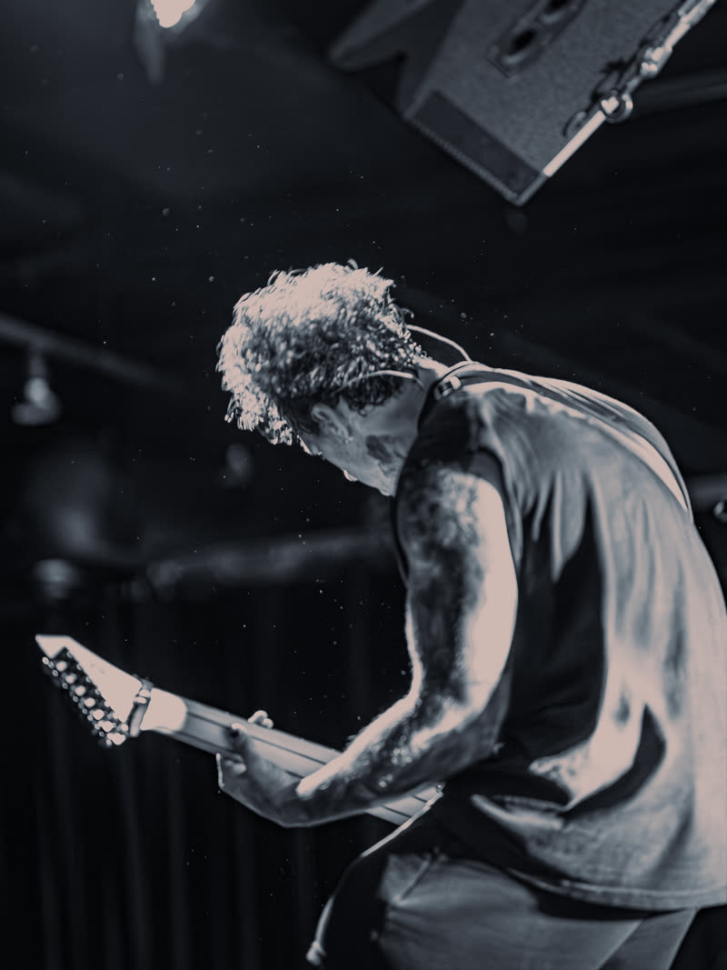 Guitarist bent over the neck