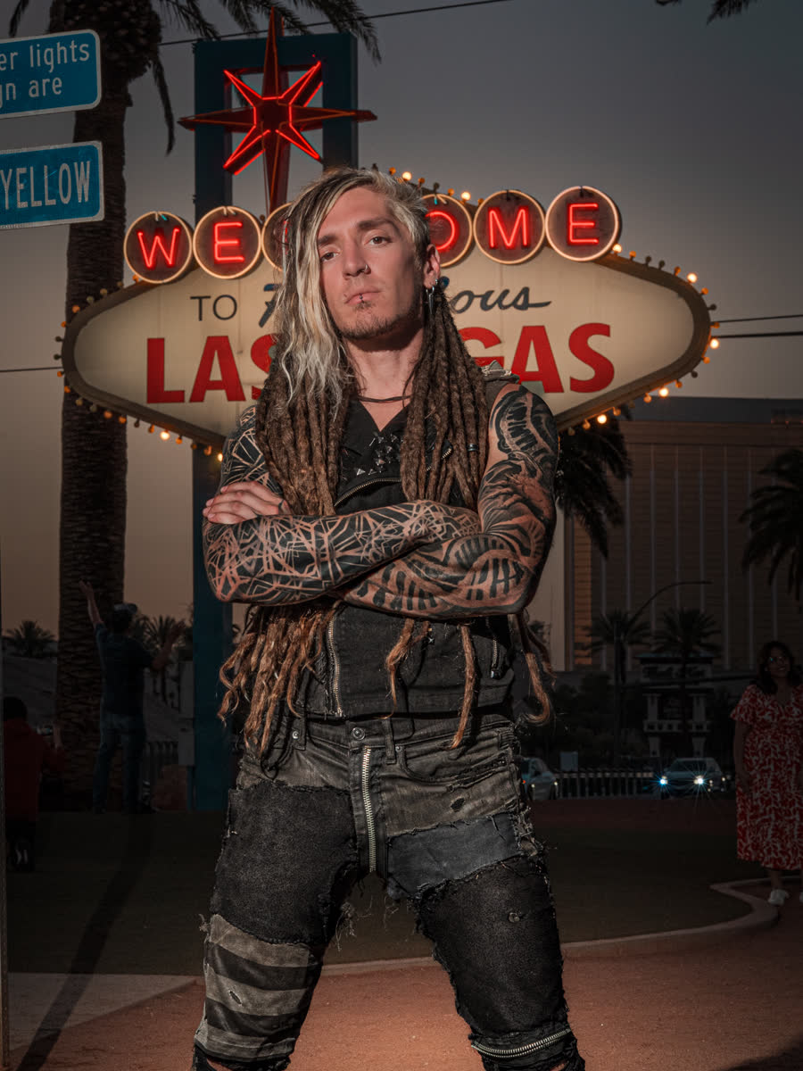 Kevin Cadaver standing at the Welcome to Fabulous Las Vegas sign at dusk