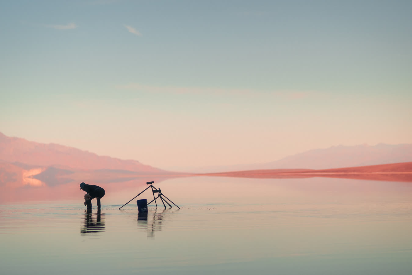 Two tripods silhouetted on the mirror at first light