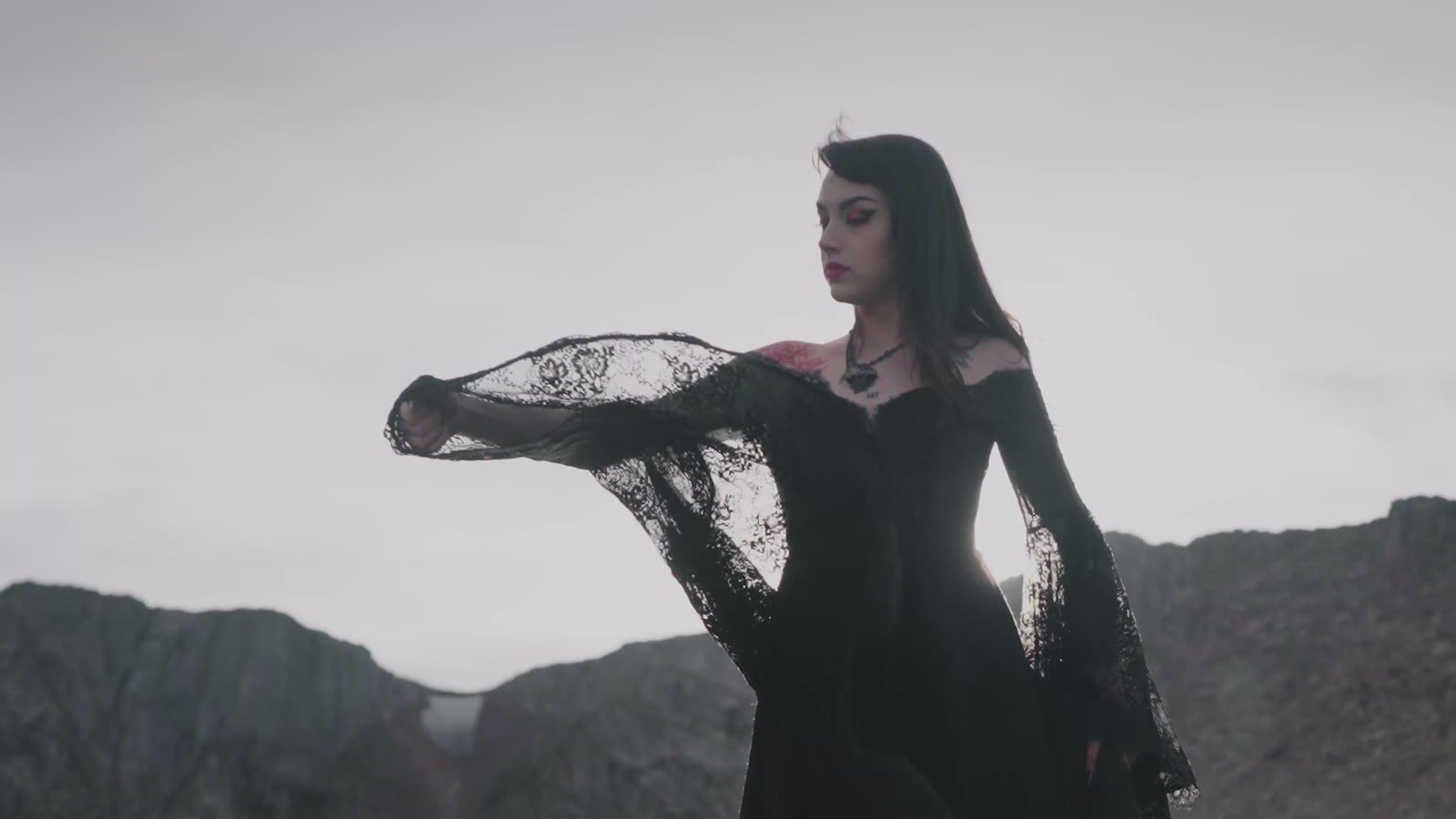 Black veil caught in the wind above an alpine lake