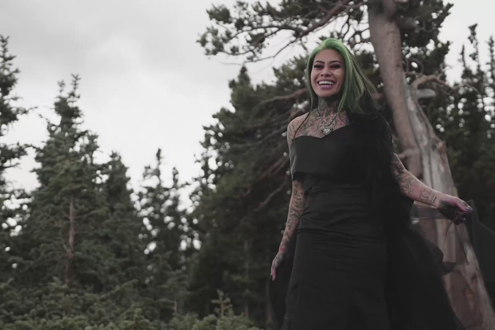 Standing among the pines in full gown