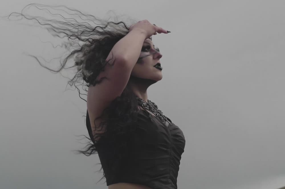 Hair thrown back against a white sky