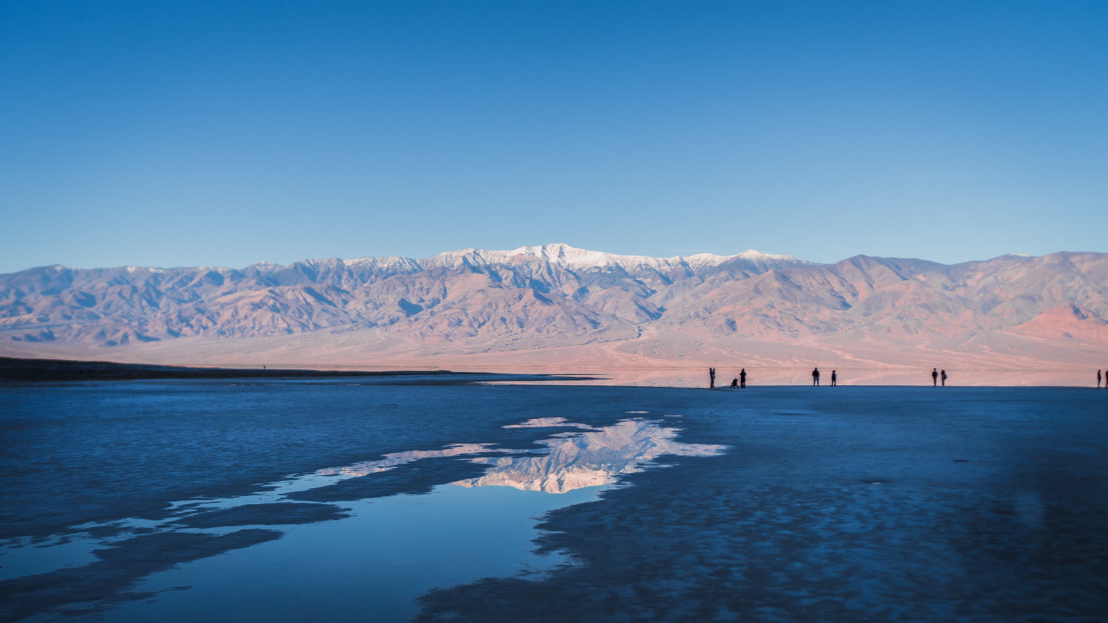 Distant figures out on the flooded pan