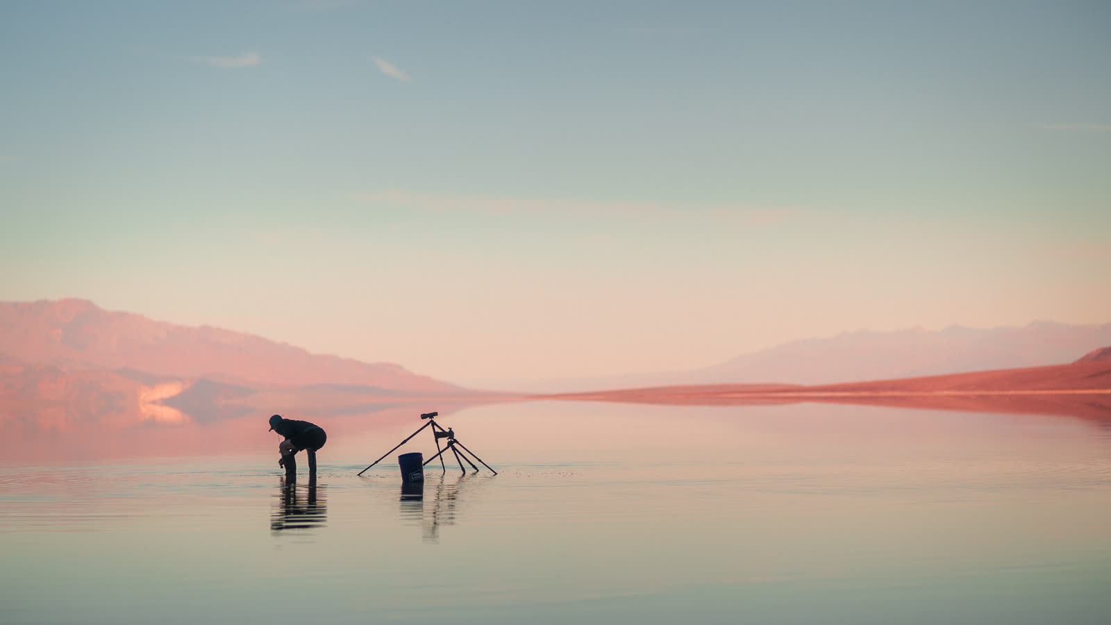 Two tripods silhouetted on the mirror at first light