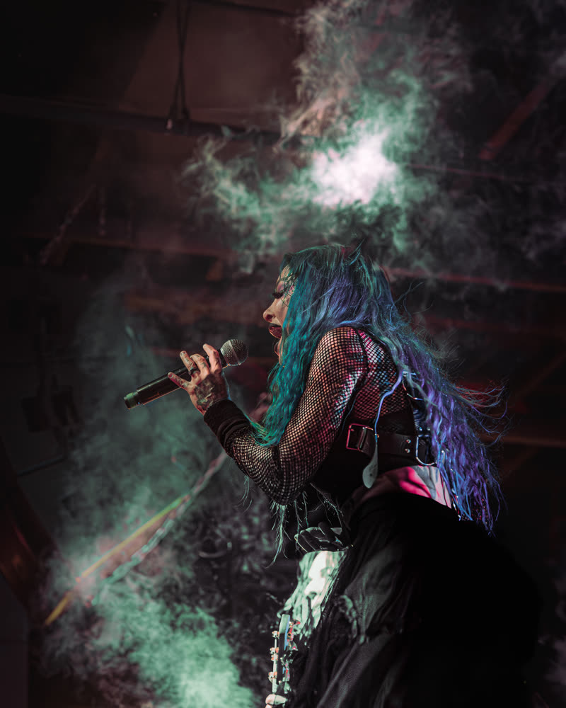 Teal smoke crossing the vocalist