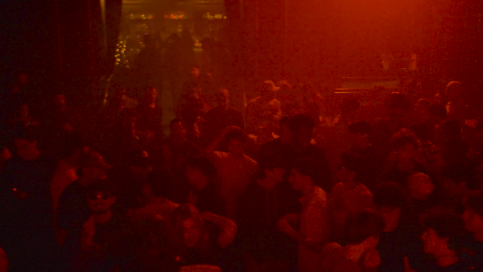 Red haze over the crowd, beams cutting through it