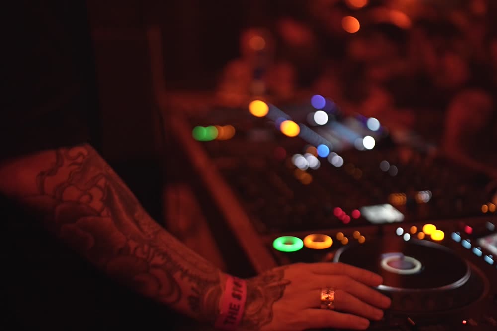 Tattooed hands working the CDJs