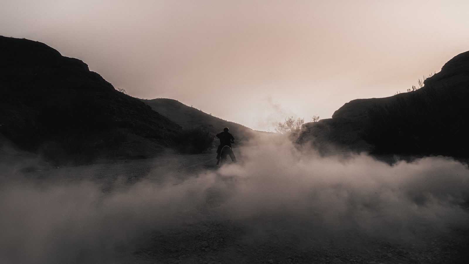 Rider swallowed by his own dust against the ridge line