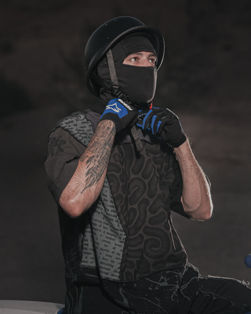 Pulling the balaclava up, printed shirt and gloves