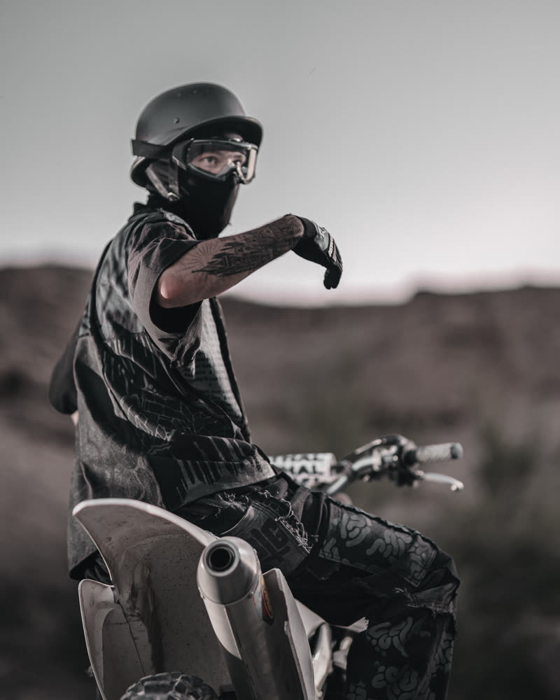 Seated on the bike in the printed shirt and trousers
