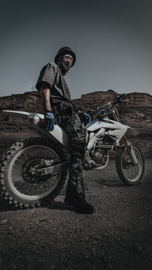 Rider on a dirt bike in the desert at last light, Justin Mensinger lookbook